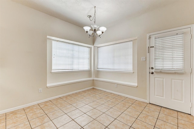 17935 Western Pass Ln, Houston, TX 77095 - unfurnished dining area with a chandelier, healthy amount of natural light, light tile patterned floors, and baseboards