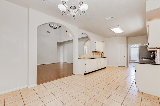 17935 Western Pass Ln, Houston, TX 77095 - kitchen with a chandelier, arched walkways, backsplash, and light tile patterned floors