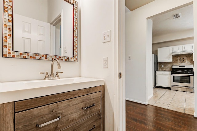 17935 Western Pass Ln, Houston, TX 77095 - bathroom with vanity, wood finished floors, backsplash, and baseboards