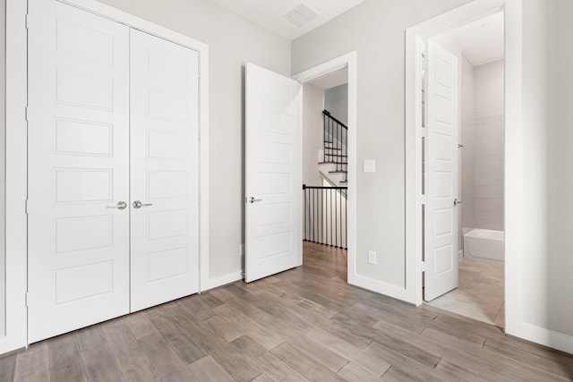 2653 Fountain Key Blvd, Houston, TX 77008 - unfurnished bedroom featuring light wood-style floors, baseboards, a closet, and ensuite bathroom