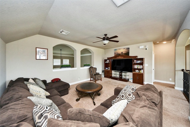 31602 Hummingbird Oak Dr, Hockley, TX 77447 - carpeted living area with a textured ceiling, baseboards, a ceiling fan, lofted ceiling, and arched walkways