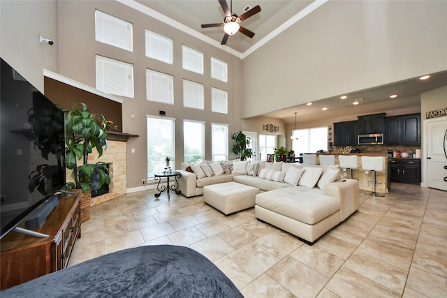 31602 Hummingbird Oak Dr, Hockley, TX 77447 - living room with ceiling fan, ornamental molding, a stone fireplace, a high ceiling, and recessed lighting