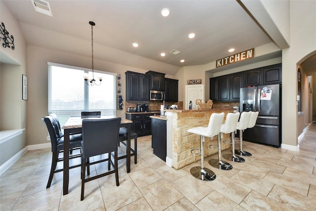 31602 Hummingbird Oak Dr, Hockley, TX 77447 - kitchen with stainless steel appliances, backsplash, arched walkways, a kitchen bar, and a chandelier