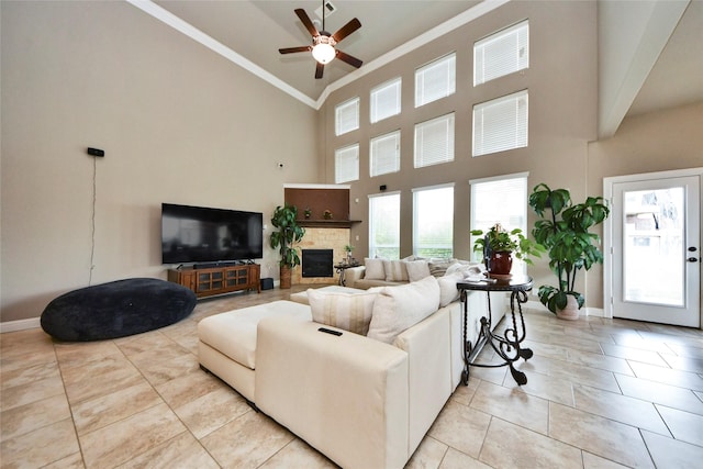 31602 Hummingbird Oak Dr, Hockley, TX 77447 - living area featuring crown molding, a glass covered fireplace, plenty of natural light, ceiling fan, and high vaulted ceiling