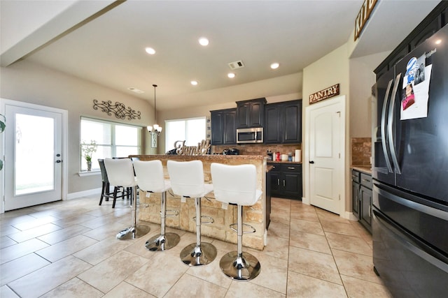 31602 Hummingbird Oak Dr, Hockley, TX 77447 - kitchen featuring smart refrigerator, stainless steel microwave, tasteful backsplash, recessed lighting, and a center island with sink