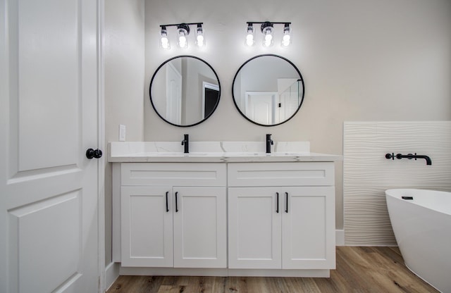 4506 Knights Ct, Baytown, TX 77521 - bathroom featuring double vanity, wood finished floors, and a freestanding bath