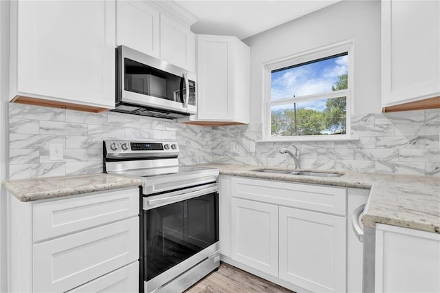 189 W Lakeview Wood, Onalaska, TX 77360 - kitchen featuring stainless steel appliances, a sink, white cabinets, and light stone countertops