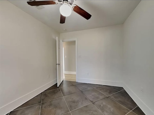 5939 Belcrest St, Houston, TX 77033 - unfurnished room featuring baseboards, dark tile patterned flooring, and a ceiling fan
