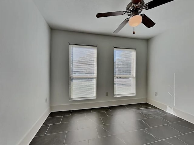 5939 Belcrest St, Houston, TX 77033 - spare room with baseboards, dark tile patterned flooring, and a ceiling fan