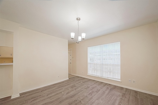 3968 Belle Park Dr, Houston, TX 77072 - spare room with wood finished floors, a chandelier, and baseboards