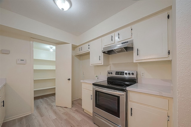 3968 Belle Park Dr, Houston, TX 77072 - kitchen with stainless steel range with electric cooktop, under cabinet range hood, light wood-style floors, and light countertops