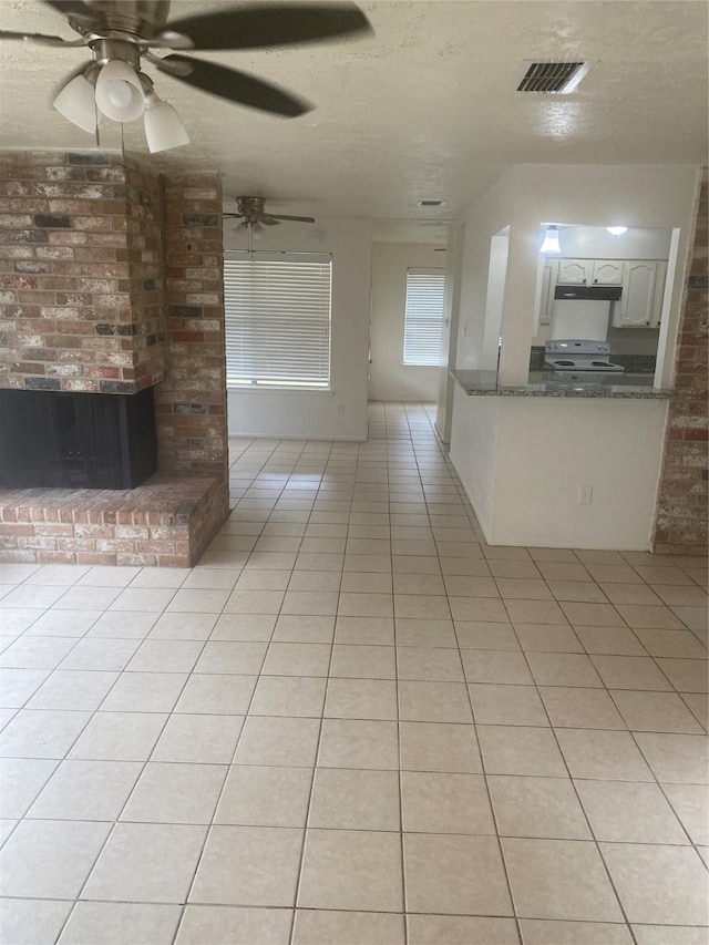 22307 Fincastle Dr, Katy, TX 77450 - unfurnished living room featuring light tile patterned floors, a ceiling fan, and a textured ceiling