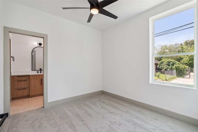 2949 Delafield St, Houston, TX 77023 - unfurnished bedroom with light colored carpet, a sink, connected bathroom, and baseboards