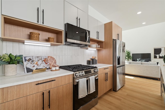 2949 Delafield St, Houston, TX 77023 - kitchen with stainless steel appliances, open shelves, decorative backsplash, light wood finished floors, and open floor plan