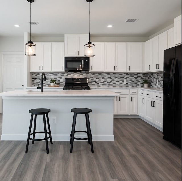 318 New Hampshire St, Houston, TX 77029 - kitchen featuring black appliances, a sink, dark wood-style flooring, decorative backsplash, and recessed lighting