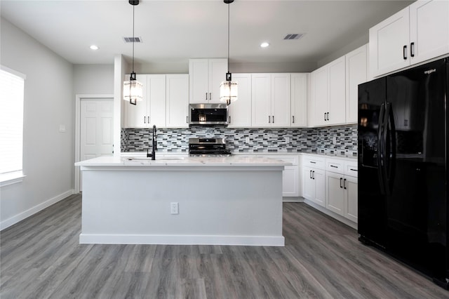 318 New Hampshire St, Houston, TX 77029 - kitchen with stainless steel appliances, a sink, decorative backsplash, wood finished floors, and recessed lighting