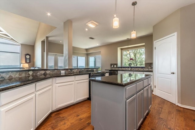 1328 Lakepark Dr, Lakehills, TX 78063 - kitchen with decorative backsplash, dark stone countertops, dark wood-style flooring, a kitchen island, and hanging light fixtures