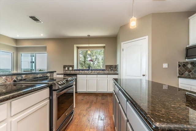1328 Lakepark Dr, Lakehills, TX 78063 - kitchen with stainless steel range with electric stovetop, decorative backsplash, decorative light fixtures, dark wood finished floors, and dark stone counters