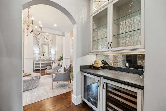 5659 Willers Way, Houston, TX 77056 - indoor dry bar with arched walkways, wine cooler, tasteful backsplash, and dark wood finished floors