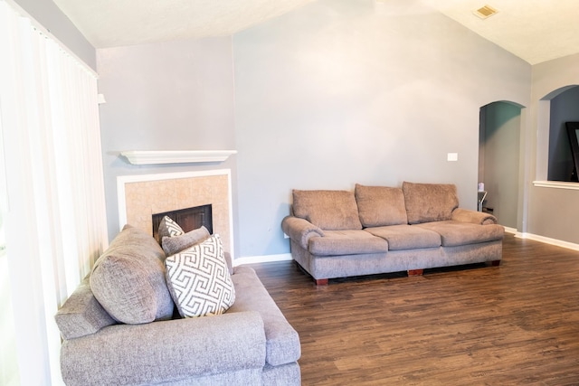 3906 Cyril Dr, Humble, TX 77396 - living room featuring arched walkways, wood finished floors, baseboards, a fireplace, and lofted ceiling