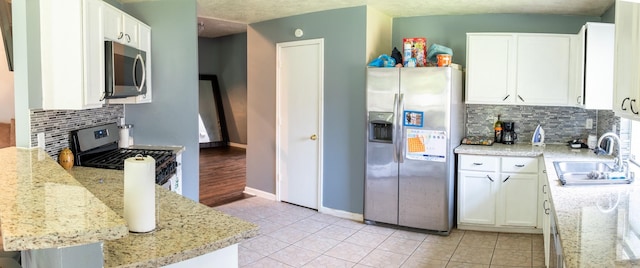3906 Cyril Dr, Humble, TX 77396 - kitchen with stainless steel appliances, a sink, tasteful backsplash, white cabinets, and light tile patterned flooring