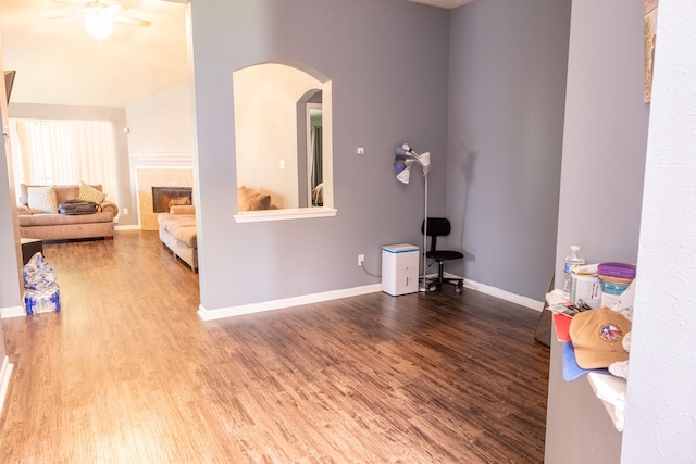 3906 Cyril Dr, Humble, TX 77396 - unfurnished living room with arched walkways, wood finished floors, baseboards, and a ceiling fan