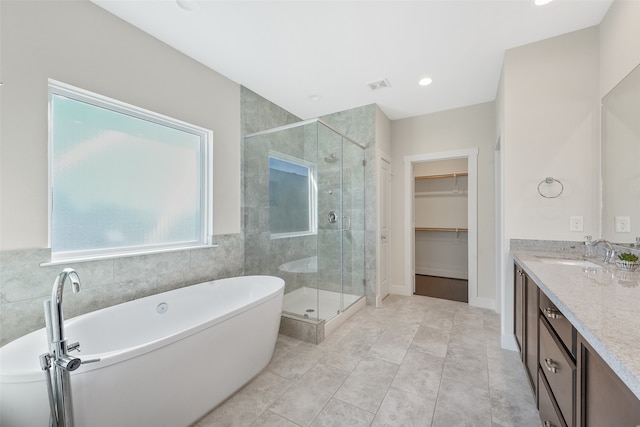 824 W 20th St, Houston, TX 77008 - full bath with a stall shower, vanity, a freestanding bath, a walk in closet, and tile patterned flooring
