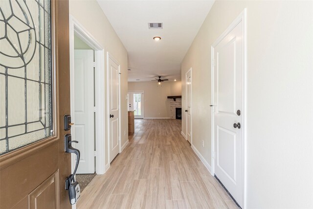 217 E Southland Ave, Alvin, TX 77511 - entryway featuring a fireplace, light wood-style floors, ceiling fan, and baseboards