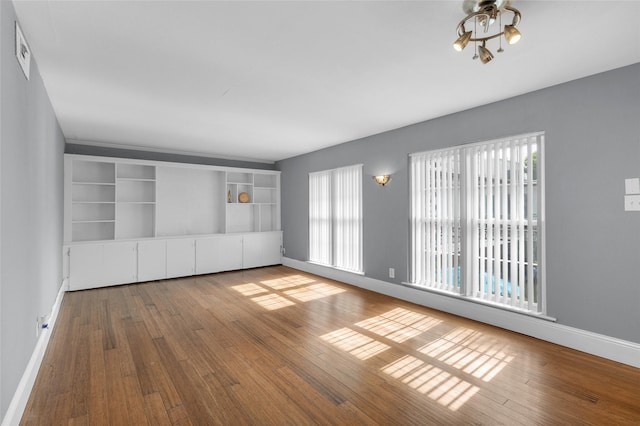 1909 Brun St Unit 17, Houston, TX 77019 - unfurnished living room with plenty of natural light, baseboards, and wood finished floors