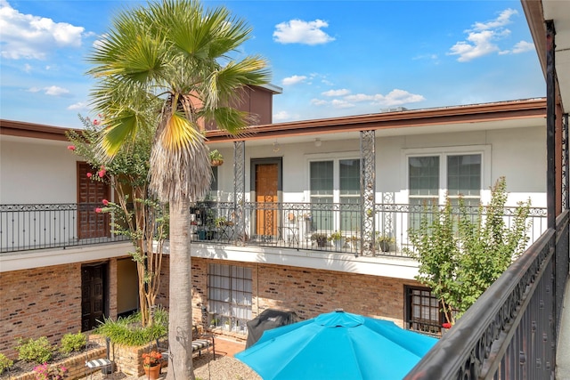1909 Brun St Unit 17, Houston, TX 77019 - view of side of property featuring stucco siding, a balcony, and brick siding