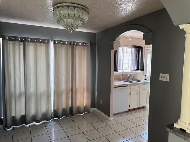 13023 High Star Dr, Houston, TX 77072 - kitchen featuring white dishwasher, arched walkways, a sink, white cabinets, and light tile patterned floors
