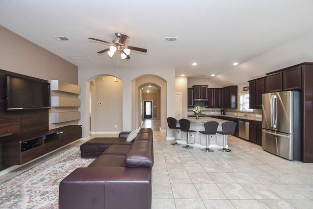 19527 Sundance Edge Ct, Richmond, TX 77407 - living area featuring arched walkways, ceiling fan, vaulted ceiling, recessed lighting, and baseboards