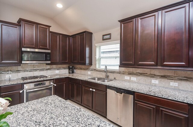 19527 Sundance Edge Ct, Richmond, TX 77407 - kitchen featuring stainless steel appliances, a sink, lofted ceiling, and decorative backsplash