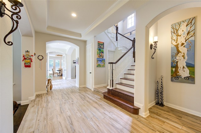 62 W Mirror Ridge Cir, The Woodlands, TX 77382 - entrance foyer featuring arched walkways, wood finished floors, a tray ceiling, stairway, and recessed lighting