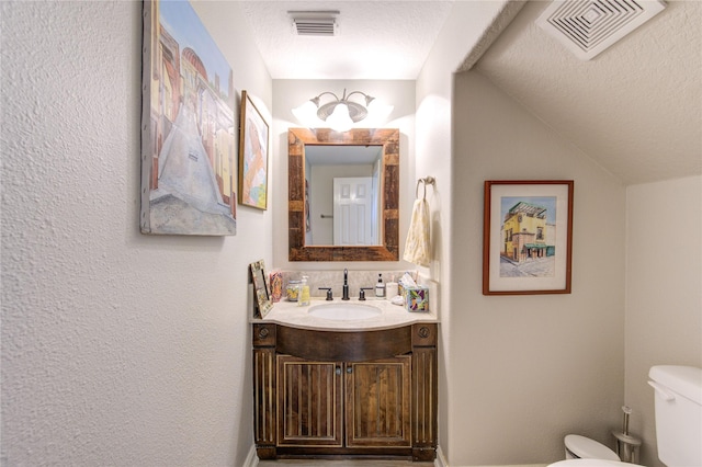 62 W Mirror Ridge Cir, The Woodlands, TX 77382 - bathroom with toilet, vanity, a textured ceiling, and vaulted ceiling
