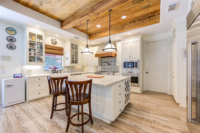 62 W Mirror Ridge Cir, The Woodlands, TX 77382 - kitchen with built in appliances, wood ceiling with exposed beams, light countertops, tasteful backsplash, and light wood-style flooring