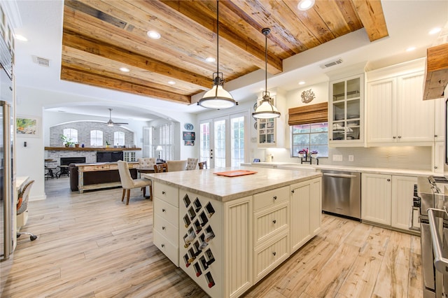 62 W Mirror Ridge Cir, The Woodlands, TX 77382 - kitchen featuring appliances with stainless steel finishes, wooden ceiling with exposed beams, a fireplace, light wood-type flooring, and recessed lighting