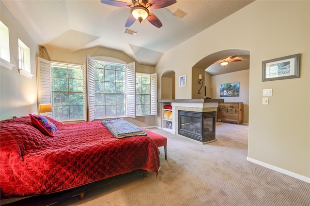 62 W Mirror Ridge Cir, The Woodlands, TX 77382 - carpeted bedroom featuring multiple windows, baseboards, a tile fireplace, and vaulted ceiling