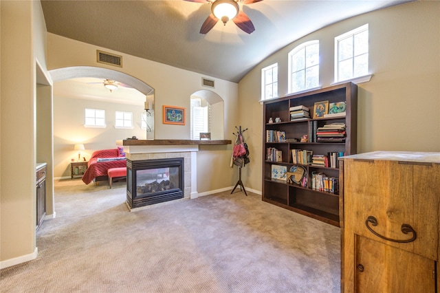 62 W Mirror Ridge Cir, The Woodlands, TX 77382 - living area featuring a ceiling fan, a fireplace, vaulted ceiling, carpet, and arched walkways