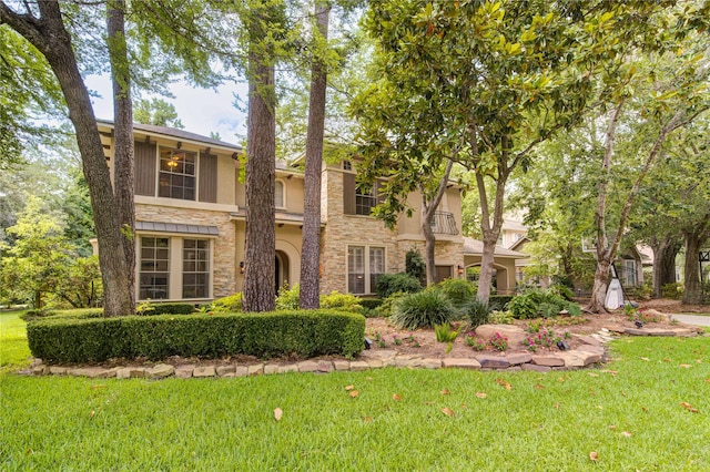 62 W Mirror Ridge Cir, The Woodlands, TX 77382 - view of front of house featuring stone siding, a front lawn, and stucco siding