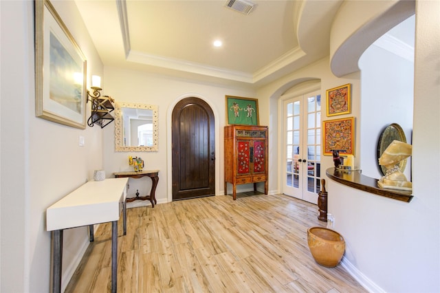 62 W Mirror Ridge Cir, The Woodlands, TX 77382 - foyer entrance featuring ornamental molding, wood finished floors, french doors, arched walkways, and a tray ceiling