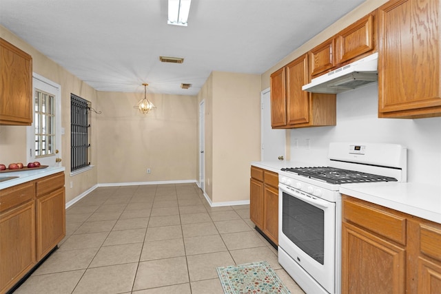 11539 Byronstone Dr, Houston, TX 77066 - kitchen featuring white gas stove, under cabinet range hood, light countertops, and a chandelier