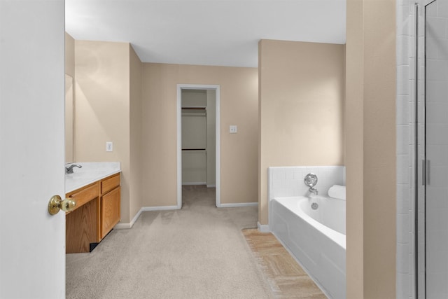 11539 Byronstone Dr, Houston, TX 77066 - full bathroom featuring vanity, a bath, baseboards, an enclosed shower, and a walk in closet