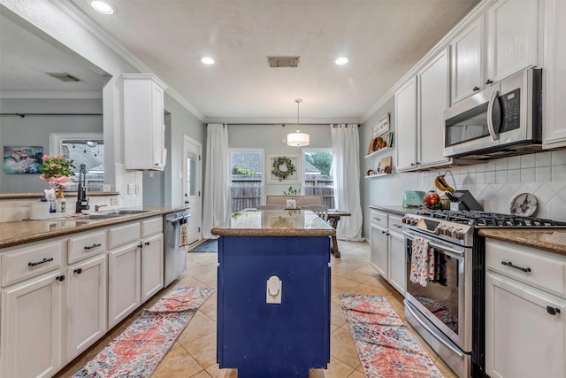 10010 Silverwood Way, Houston, TX 77070 - kitchen featuring stainless steel appliances, a sink, tasteful backsplash, a kitchen island, and white cabinets