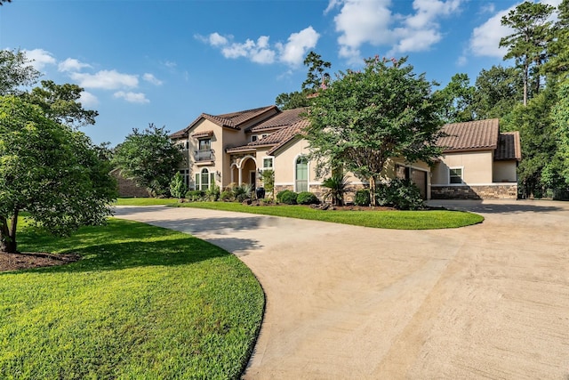 27309 S Lazy Meadow Way, Spring, TX 77386 - mediterranean / spanish home with stucco siding, curved driveway, stone siding, and a tiled roof