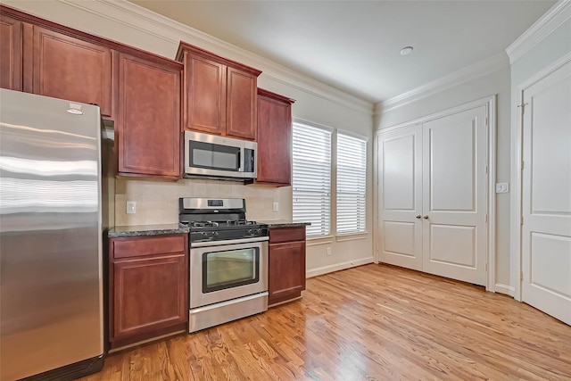 5617 Kiam St Unit A, Houston, TX 77007 - kitchen featuring stainless steel appliances, light wood-type flooring, crown molding, dark stone counters, and baseboards