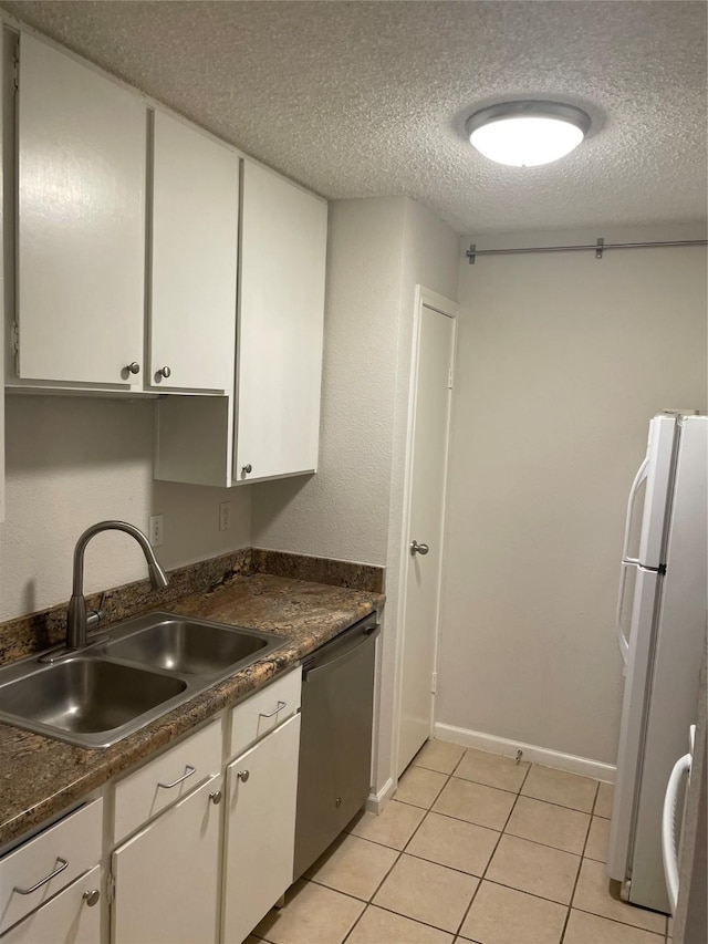 7950 N Stadium Dr Unit 132, Houston, TX 77030 - kitchen with a sink, freestanding refrigerator, a textured ceiling, stainless steel dishwasher, and white cabinets