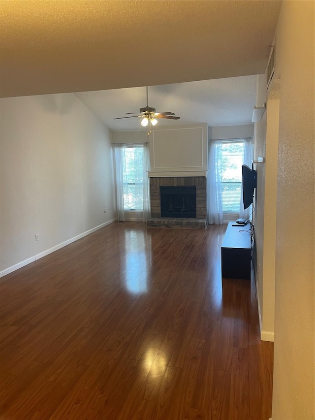 7950 N Stadium Dr Unit 132, Houston, TX 77030 - unfurnished living room with a brick fireplace, plenty of natural light, dark wood finished floors, and ceiling fan
