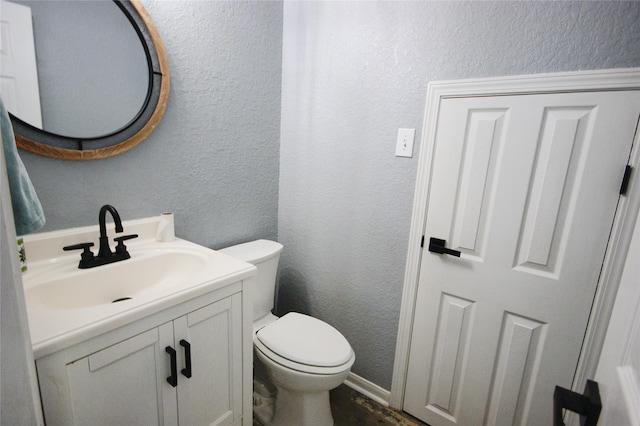 8611 Riverbend Canyon Ln, Houston, TX 77089 - half bathroom featuring vanity, a textured wall, toilet, and wood finished floors