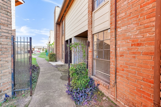 9090 S Braeswood Blvd Unit 107, Houston, TX 77074 - view of home's exterior with brick siding and a gate